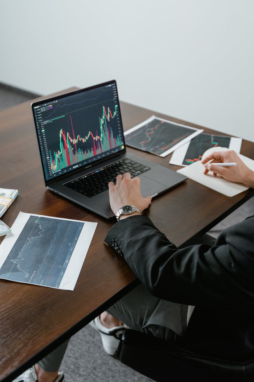Financial analyst reviewing market trends and investment opportunities on multiple screens